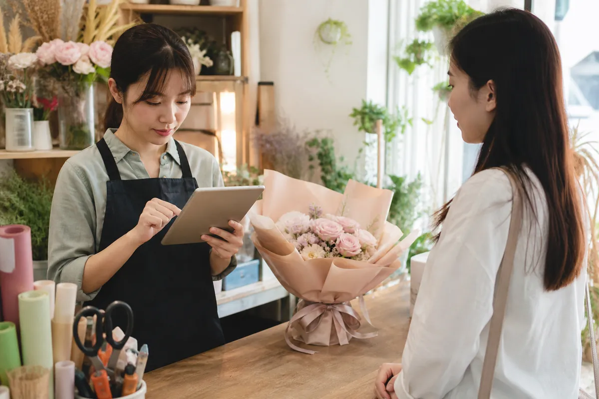 中国花店员工在交付花束前通过本店平板核验交易记录